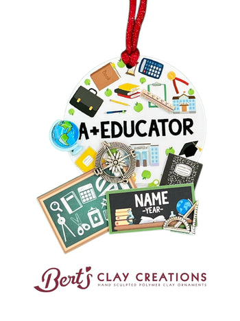 • 	Hand-sculpted polymer clay ornament for educators
• 	Miniature school-themed decorations including books, globe, pencil, and chalkboard
• 	Text reads “A+ EDUCATOR” with customizable nameplate
• 	Ornament with red ribbon for hanging
• 	Personalized holiday ornament for teachers and mentors